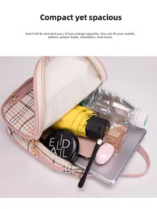Detail view of pink plaid backpack interior holding a smartphone, perfume and tablet