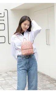 Foto en exterior de una mini mochila rosa con estampado de letras y correas ajustables