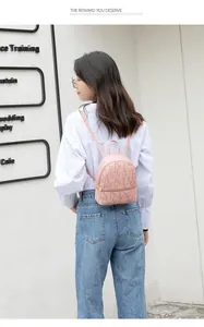 Detalle de una mini mochila rosa con estampados de letras llevada por una modelo