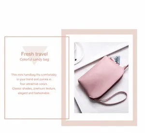 Dettaglio mini borsa a tracolla rosa con nappa blu e finitura in pelle liscia