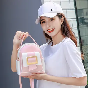 Pink and white two-tone mini backpack for women featuring a large golden square buckle