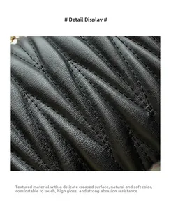 Detailed close-up of black quilted faux leather with glossy finish and refined stitching