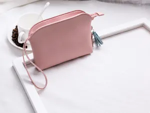 Pochette in pelle rosa con nappa blu mostrata in una scena di vita quotidiana pulita