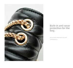 Detail of black quilted leather bag featuring gold chain strap and reinforced metal eyelets