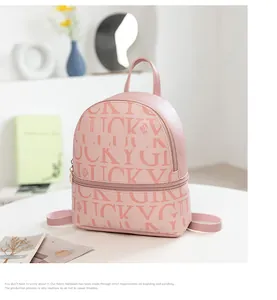 Detalle de una mini mochila rosa para mujer con motivos de letras Lucky Girl grabados