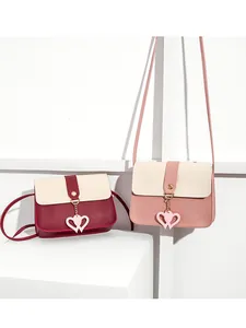 Detail view of mini crossbody bag with color-block PU leather and double heart pendant