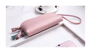 Nahaufnahme einer rosa Kunstleder-Minitasche mit blauen Quasten auf weißem Hintergrund