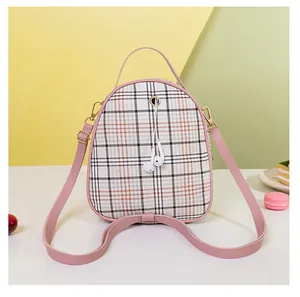Detail of plaid mini backpack with pink straps and metallic earphone port design