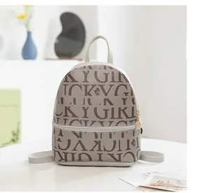 Detalle de mini mochila de cuero gris con estampado Lucky Girl en un entorno artístico