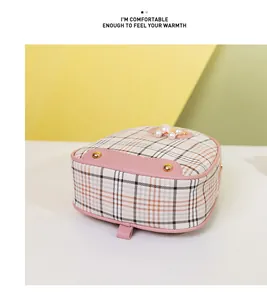 Detail of pink plaid mini bag featuring pearl accents and protective golden metal feet