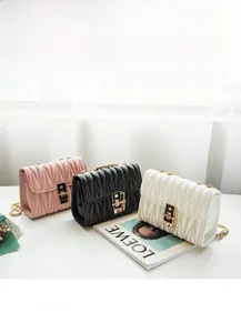 Detailed view of quilted faux leather crossbody bags with gold locks in pink, black, and white