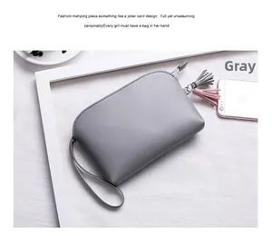 Dettaglio di una borsa da polso grigia in pelle PU con nappe bicolore rosa e grigie