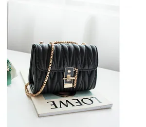 Detail of black quilted leather shoulder bag with gold square twist lock and chain strap