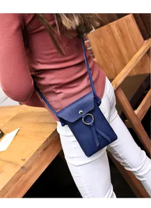 Détail du sac de téléphone bleu marine en cuir grainé avec anneau doré et pompons