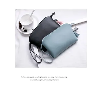 Flachbild von minimalistischen schwarzen und blauen PU-Leder-Clutches mit Quaste und Handgelenk