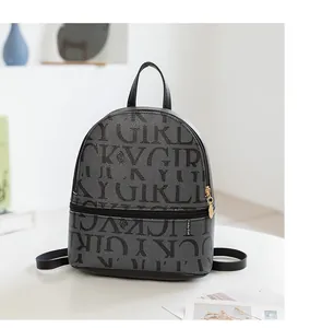 Detalle de mini mochila gris con estampado Lucky Girl y textura de piel granulada