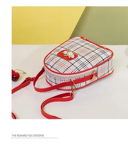Detail of red plaid crossbody bag with pearl buckle and golden zipper close-up view