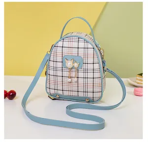 Close-up of blue plaid mini backpack with gold cat hardware and pearl charms