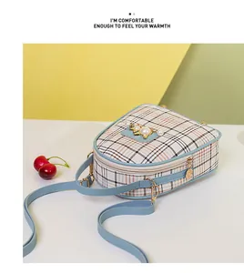 Detail of blue plaid crossbody bag featuring pearl accents and gold star buckle detail