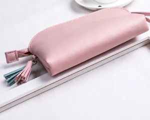 Dettaglio della borsa in pelle PU rosa con fondo arrotondato, doppia cucitura e nappina