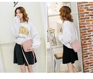 Front and back view of a pink mini crossbody bag worn by a model in a casual indoor setting