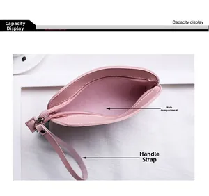Dettaglio di un portamonete rosa in pelle con cerniera lampo e cinturino da polso abbinato