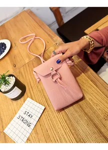 Détail du sac à téléphone en cuir PU rose avec anneau métallique et texture grainée