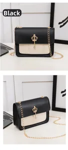 Detail of black and white leather crossbody bag with gold crown charm and chain strap