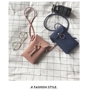 Vue détaillée de mini sacs à bandoulière en cuir rose et bleu avec anneaux en métal