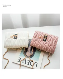 Detail of white and pink quilted chain bags with gold locks and V-shaped stitching