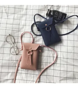 Détail de mini sacs à bandoulière en cuir grainé avec anneau doré en rose et bleu marine