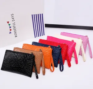 Detail of colorful crocodile pattern clutch bags with zipper and wristlet strap