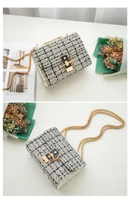 Detail of black and white plaid mini crossbody bag with golden chain and square lock