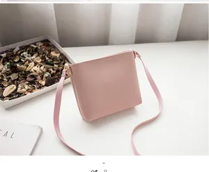 Detail shot of a minimalist pink crossbody bag with matte leather and golden hardware