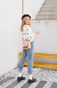 Modelo posando con mini mochila rosa y marrón con detalle de lazo metálico