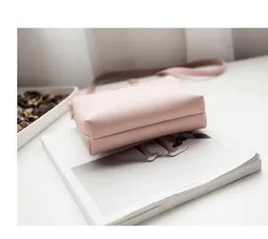 Detail shot of pink PU leather crossbody bag with refined stitching and lychee texture