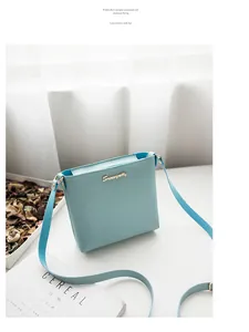 Detail of light blue PU leather bucket bag featuring a gold logo and adjustable strap