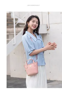 Foto lifestyle di una mini borsa a secchiello rosa a stampa coccodrillo con dettagli oro