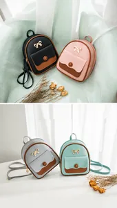 Detalle de mini mochilas en negro rosa gris y verde con lazo dorado decorativo