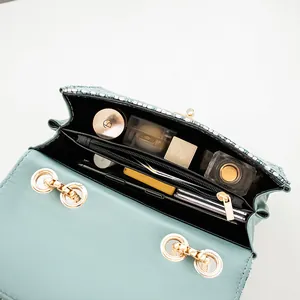 Mint green canvas shoulder bag with gold hardware and interior zipper compartment