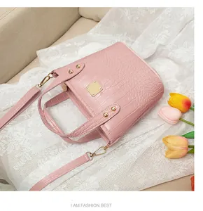 Dettaglio della texture a coccodrillo rosa e finiture in metallo dorato della borsa