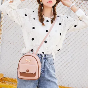 Mini mochila rosa para mujer con bolsillo marrón en contraste y hebilla de lazo dorado