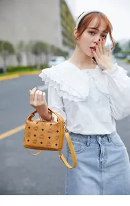 Dettaglio della mini borsa quadrata in pelle testurizzata color cammello con stampa lettere
