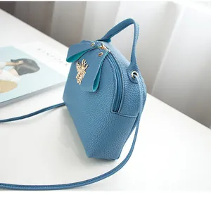 Side view of blue lychee texture mini bag with golden bee hardware and thin shoulder strap