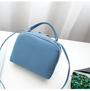 Detail of light blue lychee pattern faux leather handbag with dry flower decoration