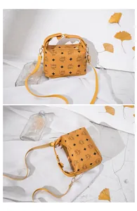 Dettaglio della borsa a tracolla giallo senape con stampa LBS e hardware dorato