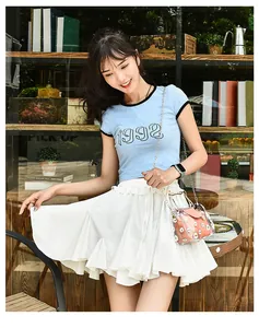 Transparent chain bag with daisy prints paired with a white ruffled tiered skirt