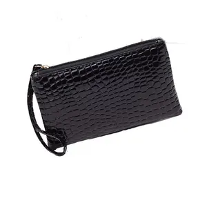 Black crocodile embossed clutch bag with wrist strap and top zipper on white background