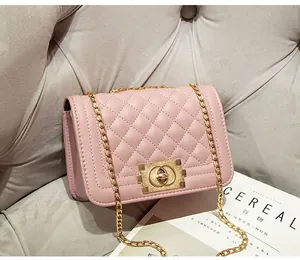 Detail van roze gewatteerde tas met gouden ketting en draaisluiting op stijlvolle achtergrond
