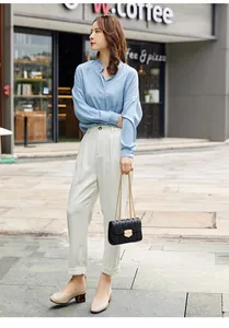 Tenue élégante avec un sac à bandoulière noir matelassé et un pantalon taille haute chic